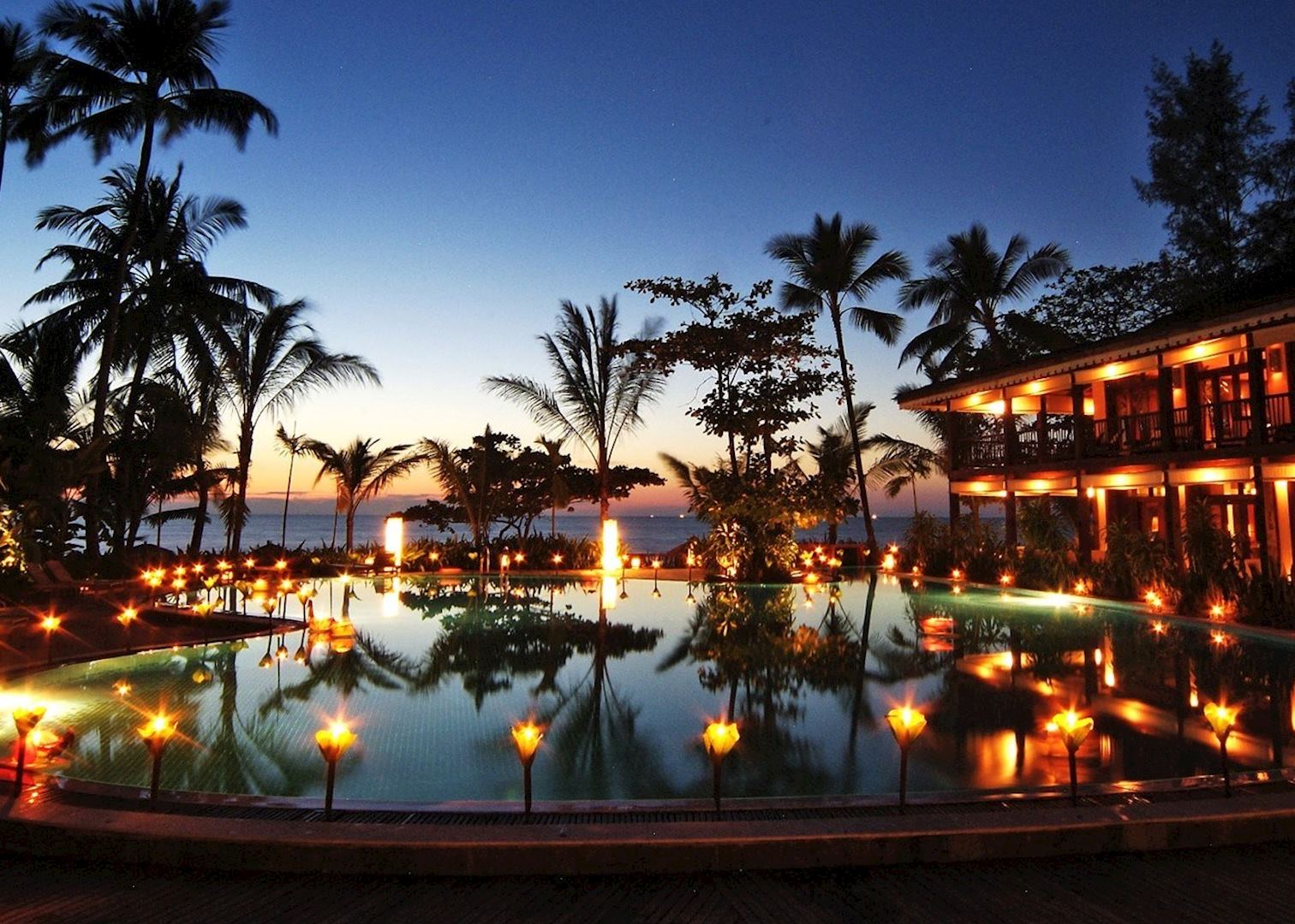 Traditional teakwood villa at Sandoway Resort under swaying coconut palms